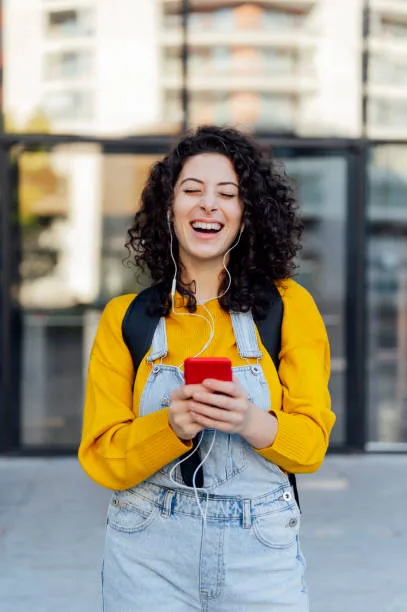 person holding phone listening to music with headphones