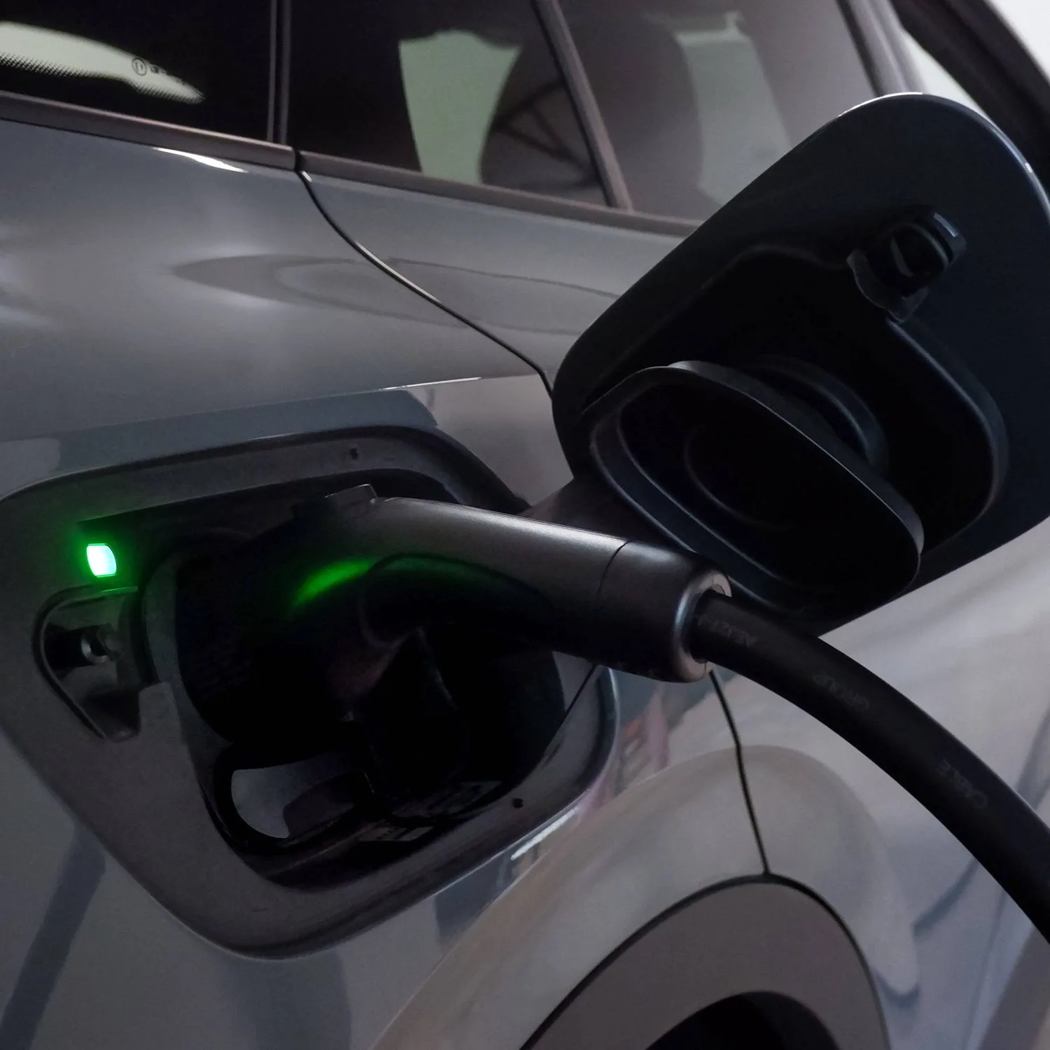 electric car charging port plugged in modern vehicle