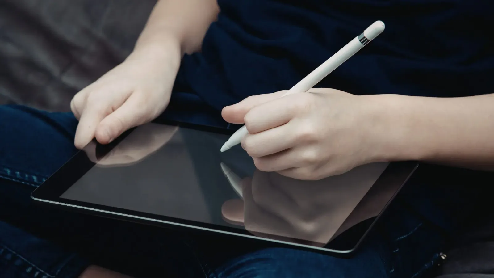 student taking notes on tablet with stylus pen
